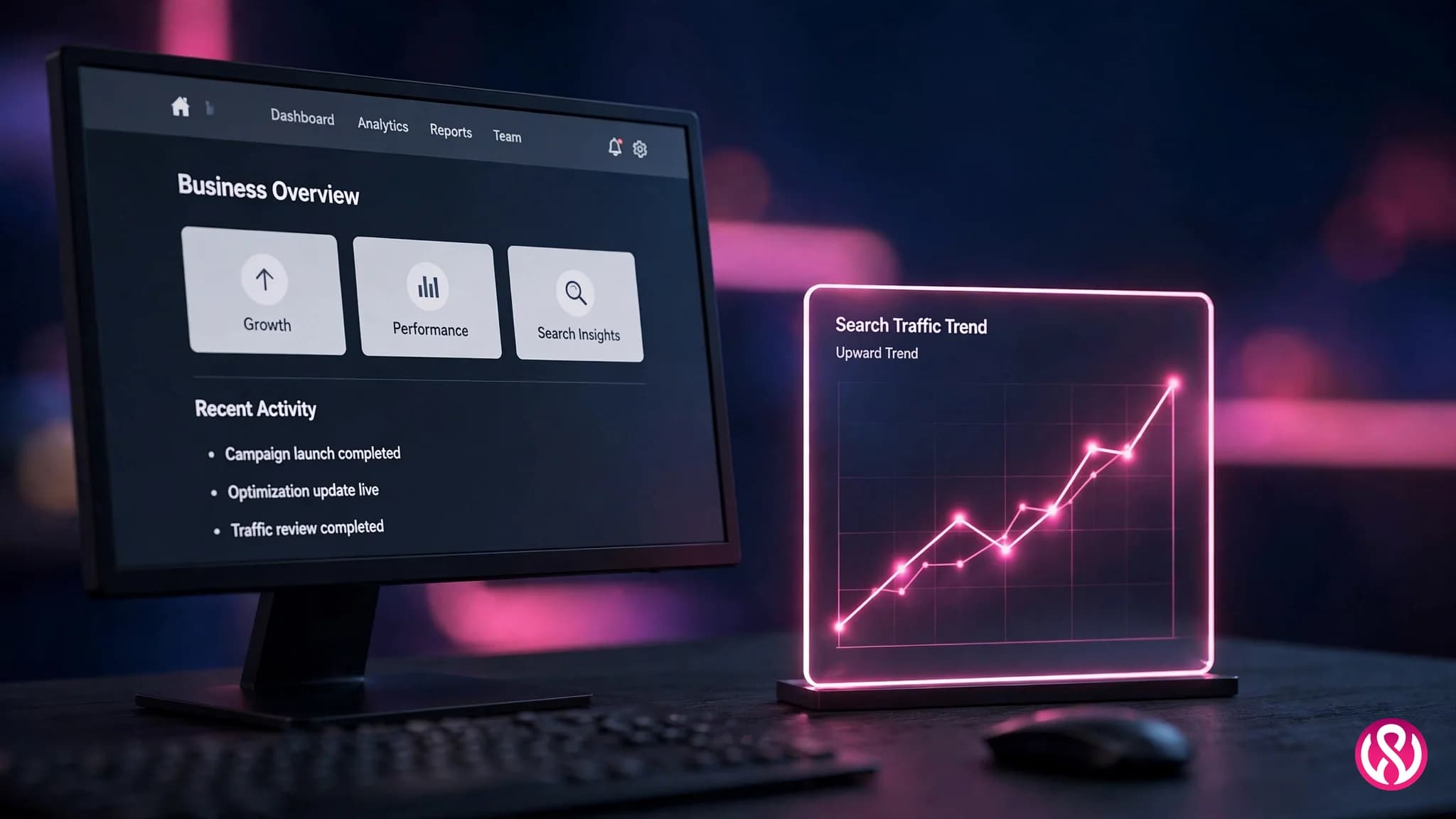 Business website on a monitor next to a search traffic trend panel on a dark desk